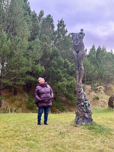 Panigkaq Agatha John Shields admiring the statue in the woods in Torshavn.
